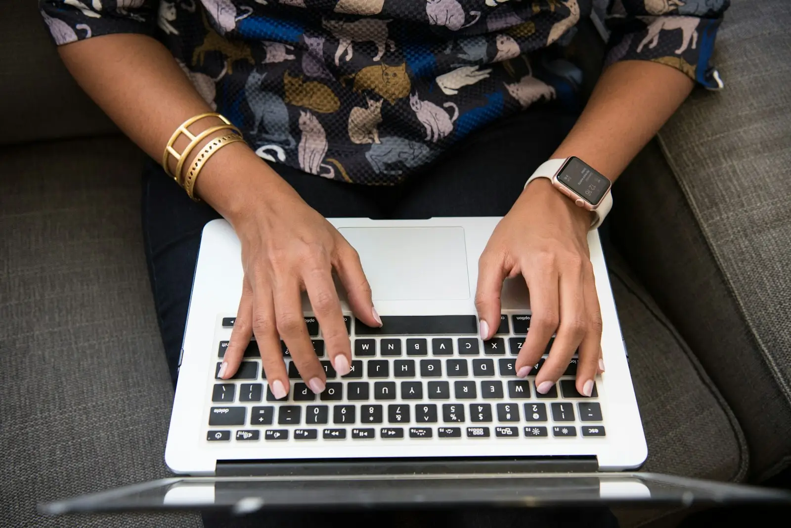 Hands typing on a laptop keyboard